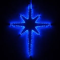 a lighted star ornament in the dark with blue lights on it's sides