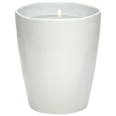 a white cup with a lit candle in it