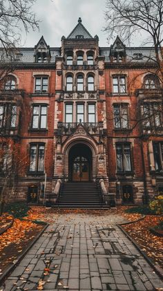 an old building with many windows and steps leading up to the front door on a cloudy day