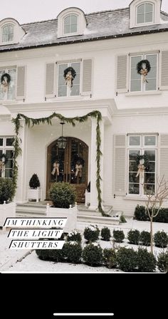 a large white house with wreaths on the front