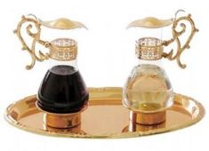 two glass bottles sitting on top of a metal tray with gold trimming and an ornate design