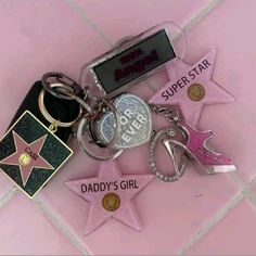 a bunch of key chains that are on top of a tile floor with pink and black stars