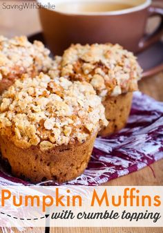 pumpkin muffins with crumble topping sitting on a napkin next to a cup of coffee