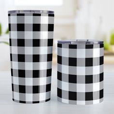 two black and white plaid tumblers sitting on top of a table