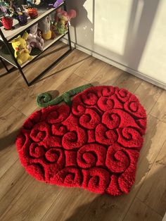 a large red rug on the floor in front of a bookshelf with stuffed animals