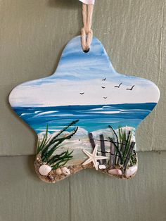 an ornament hanging from the side of a wall with sea shells and starfish