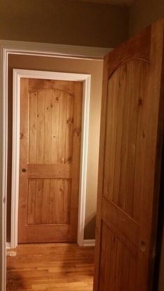 an empty room with wooden doors and hard wood flooring