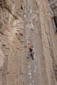 a man climbing up the side of a mountain