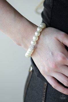 Infused with a glittery rhinestone encrusted bead, a collection of white pearls are threaded along a stretchy band around the wrist for a glamorous look. Sold as one individual bracelet. Paparazzi Accessories Jewelry, White Pearl Bracelet, Glamorous Look, White Bracelet, White Bracelets, Ball Necklace, Paparazzi Accessories, White Necklace, White Rhinestone