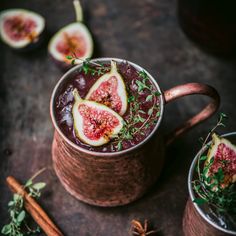 two mugs filled with liquid and sliced figs