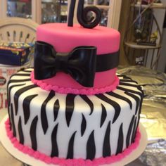 a zebra print cake with a pink bow on top