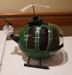 a green and black teapot shaped like a helicopter