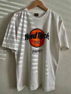 Rare Hard Rock Cafe Phuket Shirt Retro Hard Rock Cafe Phuket Shirt Vintage Hard Rock Cafe Phuket Shirt Hard Rock Cafe Shirt Hard Rock Cafe  ⏱️ SHIPPING & PRODUCTION TIME ⏱️ ∘ Please allow 1-3 business days for processing time. ∘ Shipping time is 3-5 business days. ✨ CARE INSTRUCTIONS ✨ ∘ Inside out, wash with delicate cycle ∘ Hang Dry ∘ Do not use bleach ∘ Do not iron directly onto the design ∘ Do not dry clean ↩️ RETURNS ↩️ We do not accept returns or exchanges. If you have any concerns or questions, please send us an Etsy message 💌 and we'll be happy to help! SHOP: https://www.etsy.com/shop/oatsunknown/ If you are interested in purchasing anything else in the photo, please reach out. Thank you, O.A.T.S. 🌎 Hard Rock Cafe Outfit, Hard Rock Tshirt, Cafe Outfit, Hard Rock Cafe Sweater, Hardrock Cafe, Hard Rock Cafe Shirt, Rock And Roll Screen Print Crew Neck T-shirt, See You Again Soon, Rock Cafe