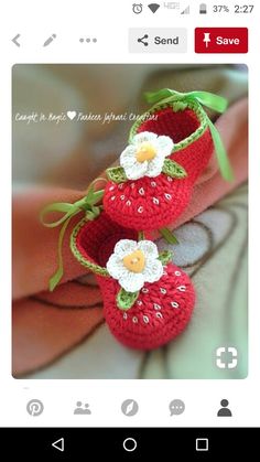 two crocheted strawberries sitting on top of each other with flowers in them