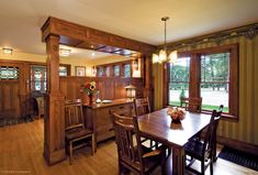 a dining room and kitchen area with wood paneling