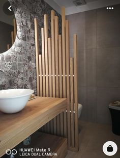 a bathroom with a sink, mirror and wooden slats on the wall behind it