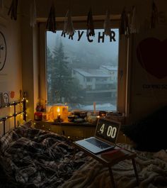 a bed room with a laptop computer on it's desk next to a window