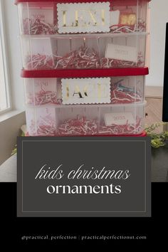 three plastic bins filled with christmas ornaments on top of a desk next to a computer