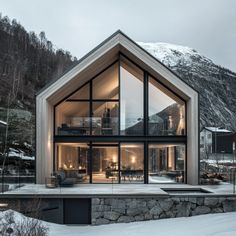 a house in the mountains with glass walls