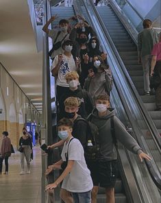 several people wearing face masks on an escalator