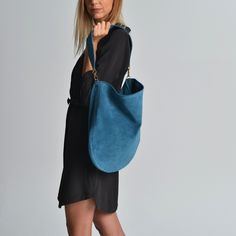 Anna suede bag in jeans blue. A beautiful  hobo bag which is ideal for every day use. Not just a shoulder bag but a statetment tote. It's loose minimalistic look makes it modern and unique.  Handmade in our studio from lux italian suede leather in jeans blue. A leather pocket made from the same leather is included at the interior. Metal details are available in gold or silver. The interior is unlined and has the same look as the exterior. Dimensions: Height, 40 cm (15,75 inches) Length, 41 cm (1 Big Leather Bag, Bag Jeans, Suede Bag, Blue Tote Bag, Suede Handbags, Leather Pocket, Blue Tote, Hobo Bags, Large Shoulder Bags