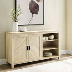 a wooden cabinet with two doors and some plates on it in front of a painting