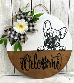 a wooden sign that says welcome with a flower in the center and an image of a dog on it