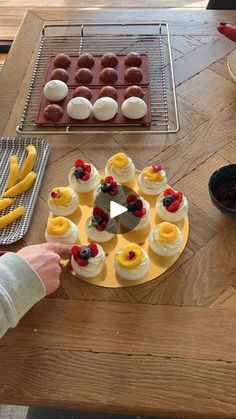 a person is decorating desserts on a table