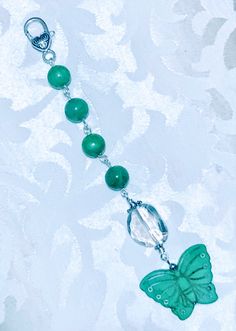 a green beaded necklace with a butterfly charm