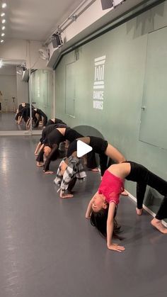 a group of people standing in a line on their hands and legs doing yoga poses