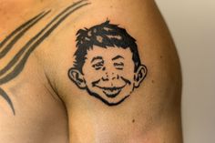 a man with a tattoo on his shoulder has a smiling face drawn on the chest