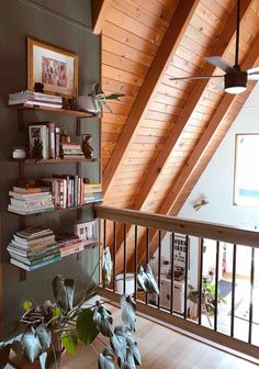 a living room filled with lots of furniture and books on top of a wooden floor