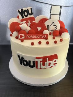 a white cake with red and black decorations on it that says youtube surrounded by hearts