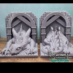 two white dragon bookends sitting on top of a wooden table next to each other