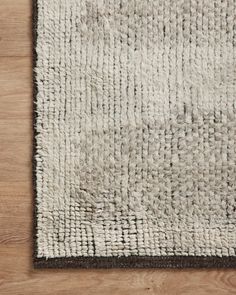 a white and brown rug on top of a wooden floor