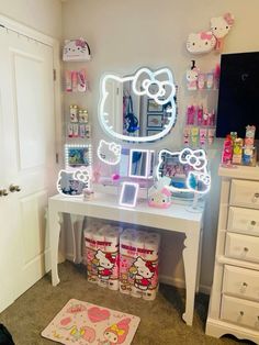 a hello kitty themed vanity with lights and makeup products on the table in front of it