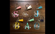 personalized acrylic keychains with tassels are displayed on a table