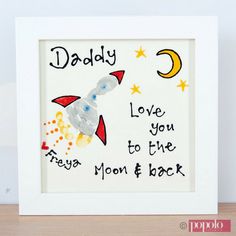 a white frame with a drawing of a rocket ship and the words daddy love you to the moon and back