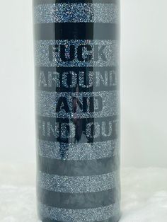 a bottle of wine that is sitting on a white tablecloth with silver glitters