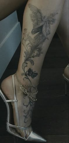 a woman's legs with tattoos and high heels