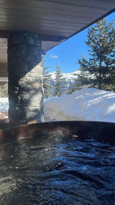 an outdoor hot tub with snow on the ground