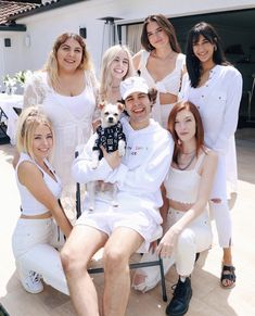 a group of people that are posing for a picture together with a dog in their lap