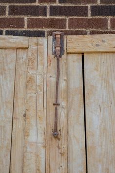 an open wooden door with a brick wall in the background