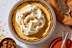 a pie sitting on top of a white table next to two bowls filled with food