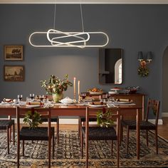 a dining room table is set with place settings and flowers on the centerpieces