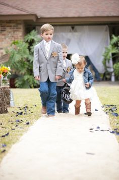 two little kids walking down a path in front of a house with confetti on the ground