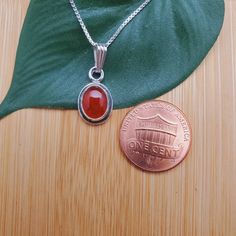 "Visit our on-line shop at: Etsy.com/shop/AlbuquerqueDesigns *sterling silver necklace pendant *Small pendant with silver box chain necklace 18\" *southwestern jewelry *carnelian / healing carnelian *calibrated pre-cut stones: 9x7mm oval shape *back of jewelry items are all covered / do not show the back of stones *all jewelry items are made to ship, slight variations in stones will occur comparing to pictures. *size of a penny is 19mm or a dime is 18mm in diameter for comparing size with jewelr Silver Carnelian Round Pendant Jewelry, Silver Carnelian Jewelry For Anniversary, Classic Silver Carnelian Jewelry, Nickel-free Carnelian Jewelry, Carnelian Oval Pendant Necklace As A Gift, Silver Carnelian Cabochon Necklace, Carnelian Oval Pendant Necklace For Gift, Orange Oval Sterling Silver Necklace, Oval Orange Sterling Silver Necklace