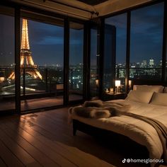 a bedroom with a view of the eiffel tower in paris, france at night