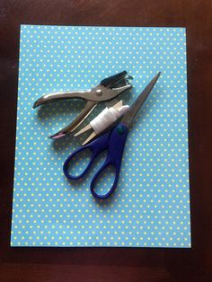 three pairs of scissors sitting on top of a blue and white dotted piece of paper