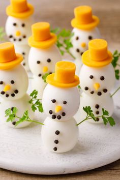 small snowmen with hats and carrots on a plate